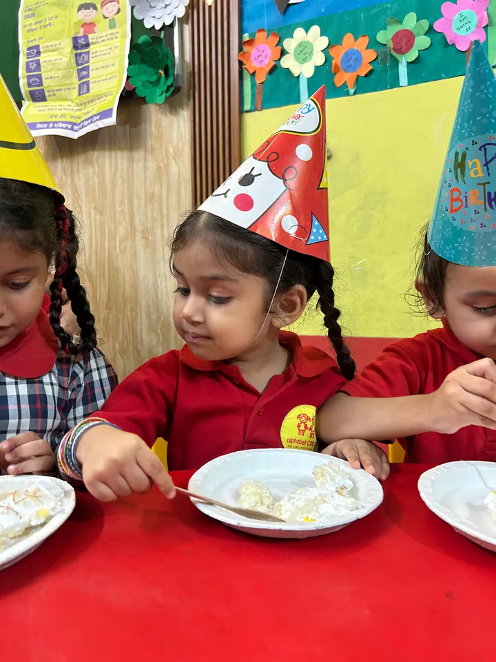 Children in party hats at the red table