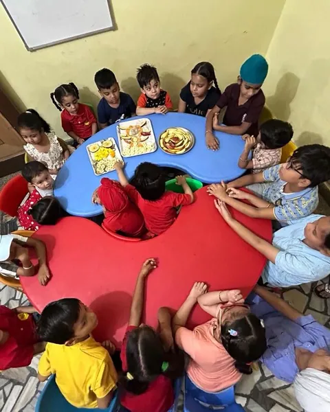 Children in the red uniform gather round the red and blue tables