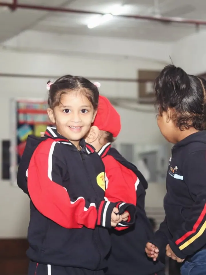 Two little girls in winter uniforms in a large hall