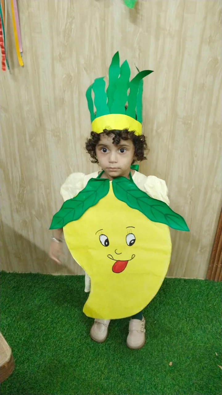 A toddler dressed as a mango