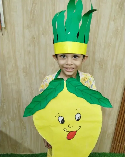A smiling child in a mango costume