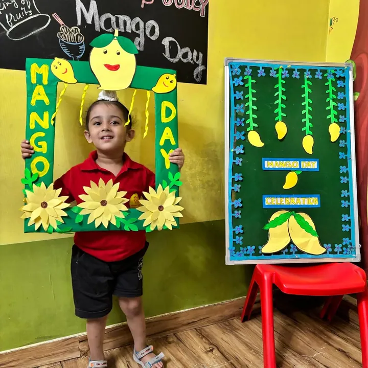 A girl in the red uniform smiles inside the Mango Day frame